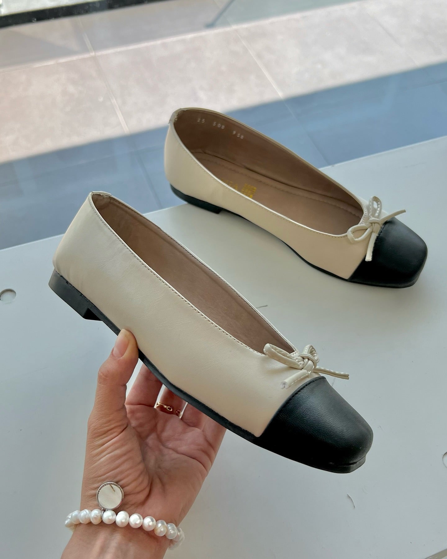 zapatilla piso nude con negro con moño